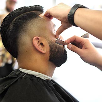 barber doing a razor line on beard